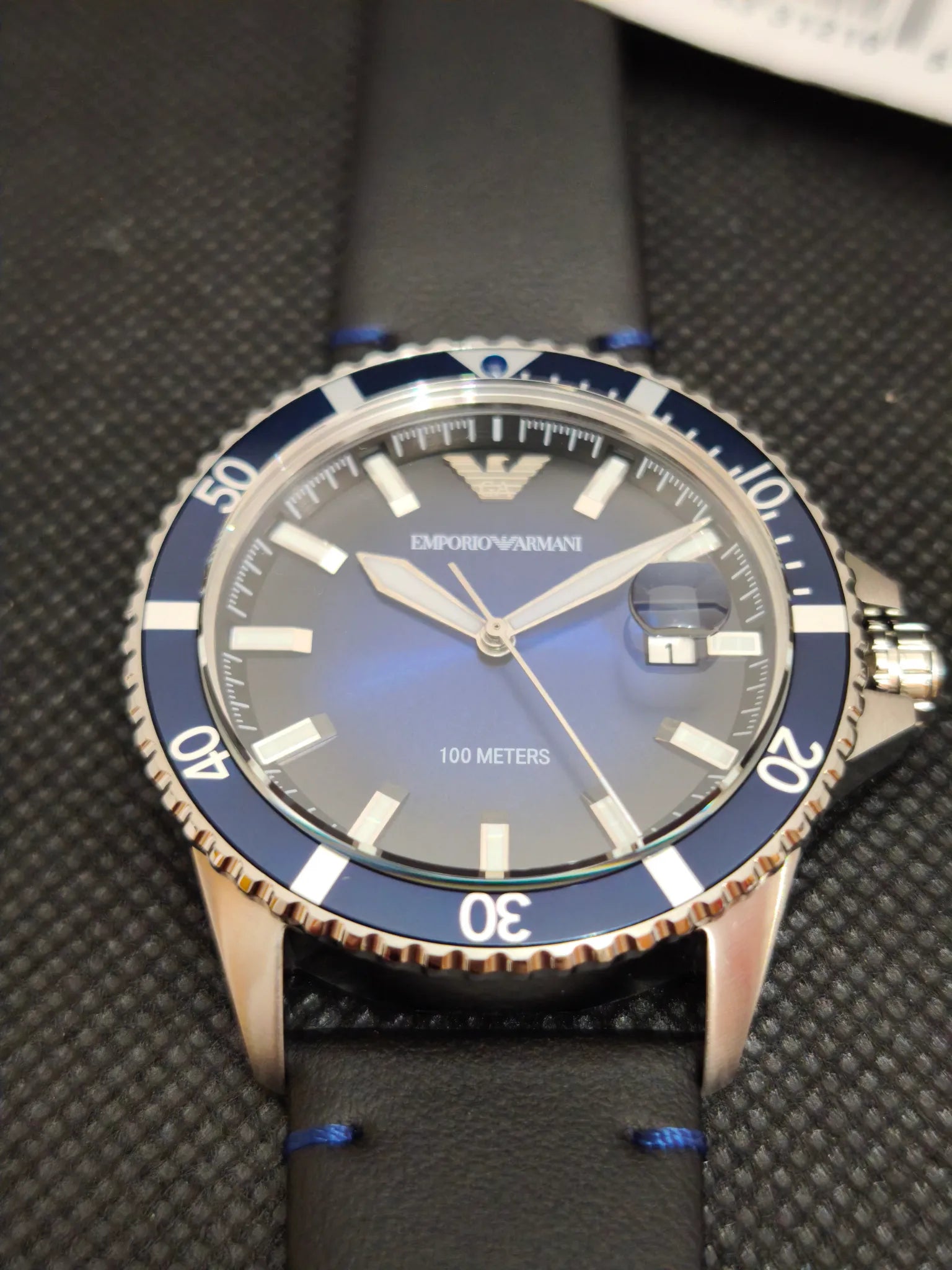 Reloj Emporio Armani AR11516 Diver en ángulo, detalle de esfera azul y ventana de fecha