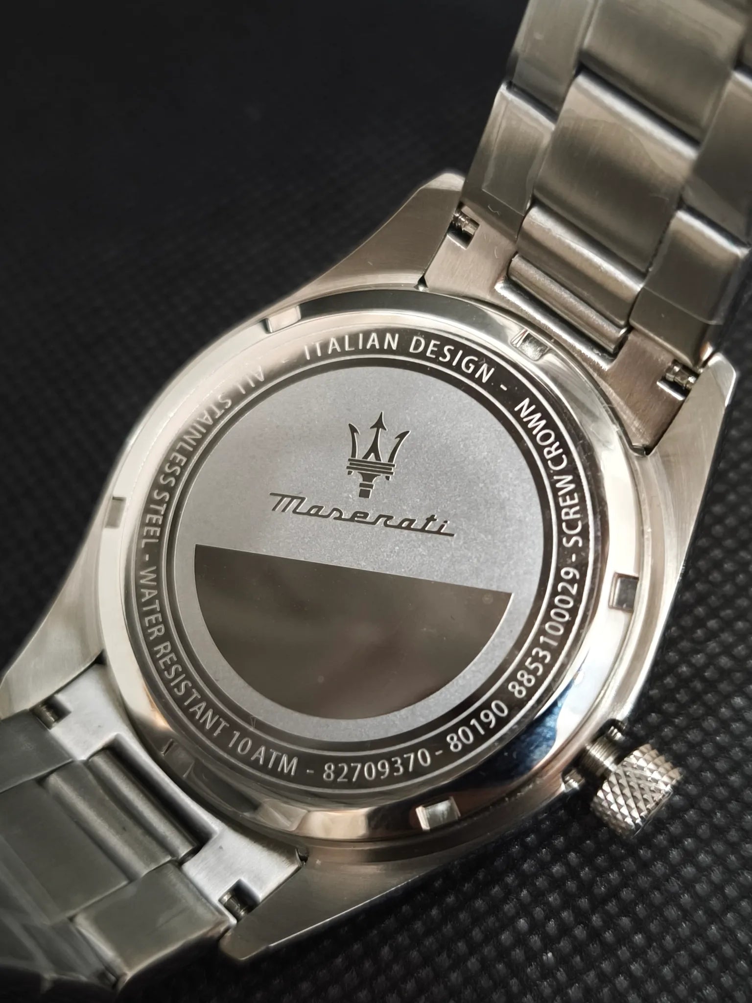 Tapa trasera en acero del Maserati R8853100029 con grabados de la marca