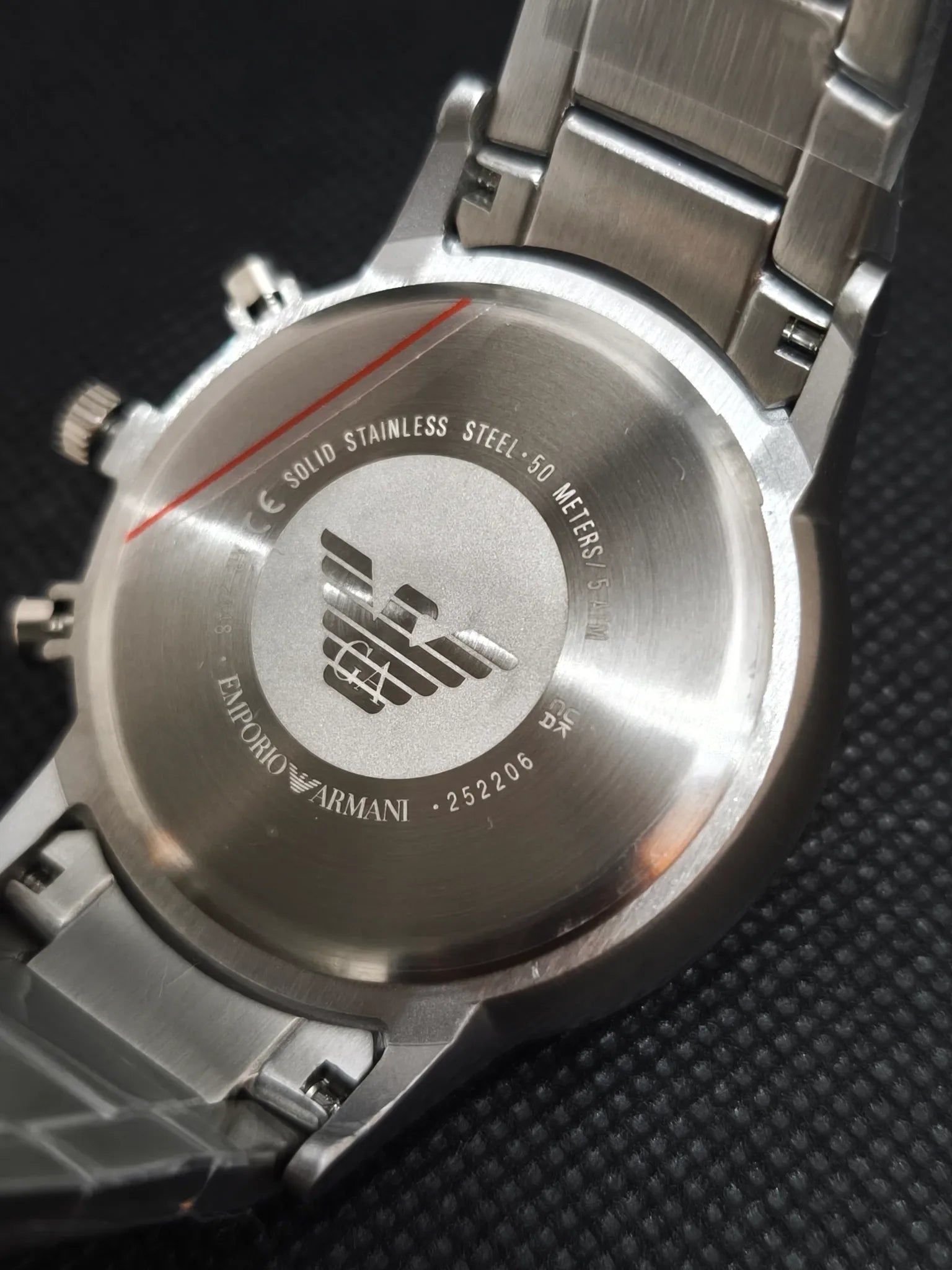 Tapa trasera del Emporio Armani AR2448 en acero con grabados