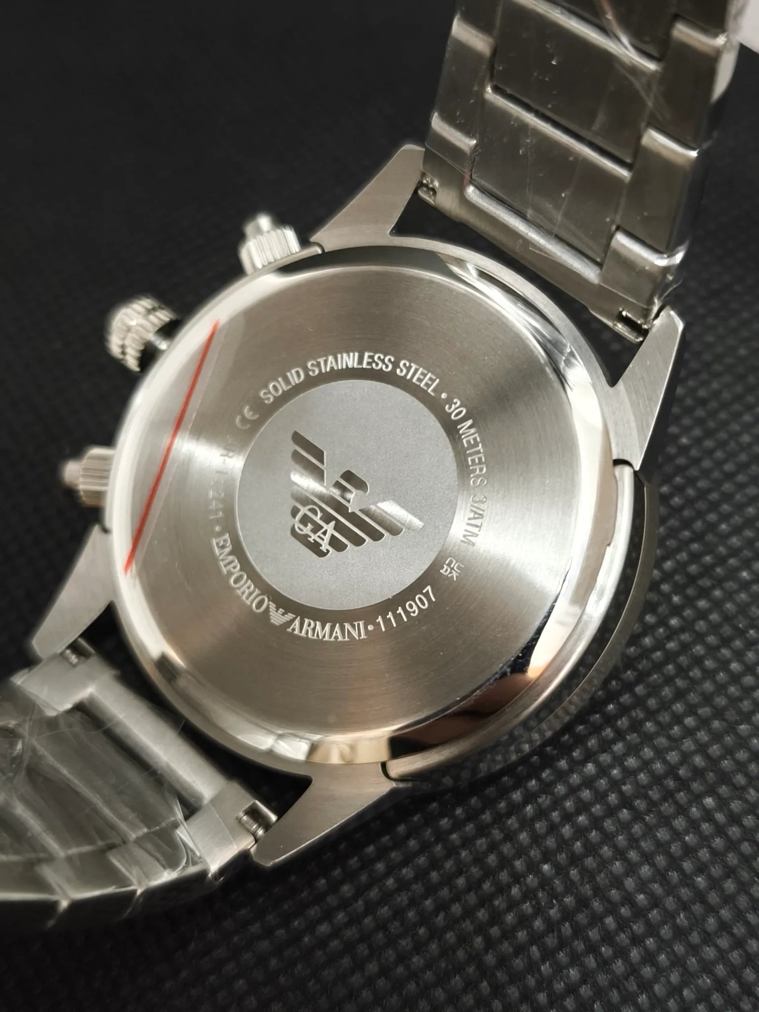 Tapa trasera en acero del Emporio Armani AR11241 con grabados de la marca