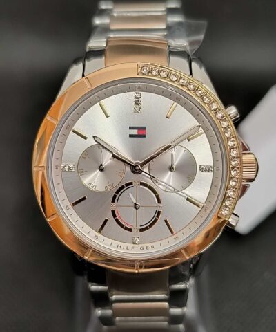 Reloj Tommy Hilfiger Kennedy TH1782387 con caja de 38 mm rosada con cristales brillantes, esfera plateada, y correa de eslabones bicolor en plateado y rosado.