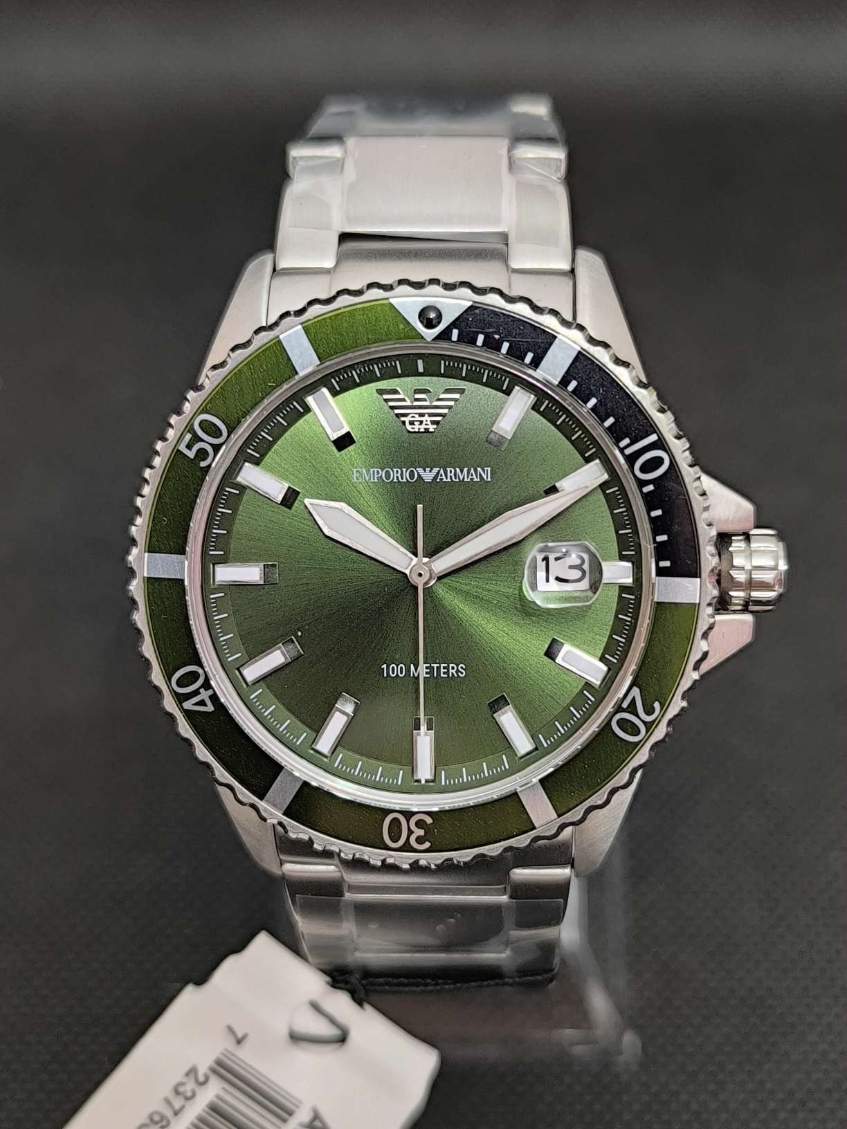 Reloj Emporio Armani Diver AR11338 cuenta con caja de 42 milímetros y correa de acero inoxidable, esfera verde con lupa para visualizar el día, bisel giratorio y resistencia al agua de 10 atmosferas (100 metros)