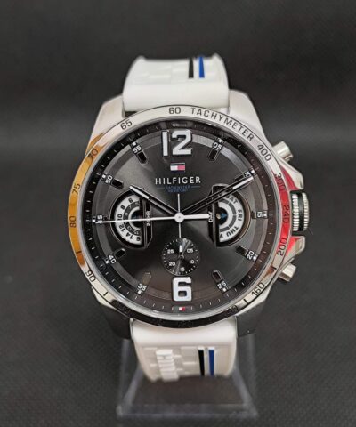 Reloj Tommy Hilfiger TH1791475, con caja de 46 mm de diámetro en acero inoxidable, esfera de color negra, correa de silicona blanca con detalles en azul que proporciona comodidad y estilo deportivo. Ideal para uso diario y ocasiones casuales, combina modernidad y funcionalidad.