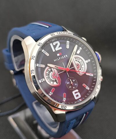 Reloj Tommy Hilfiger TH1791476, destacando su caja de 46 mm de diámetro en acero inoxidable, esfera azul con marcadores y agujas en contraste, y correa de silicona azul que proporciona comodidad y estilo deportivo. Ideal para uso diario y ocasiones casuales, combina modernidad y funcionalidad.