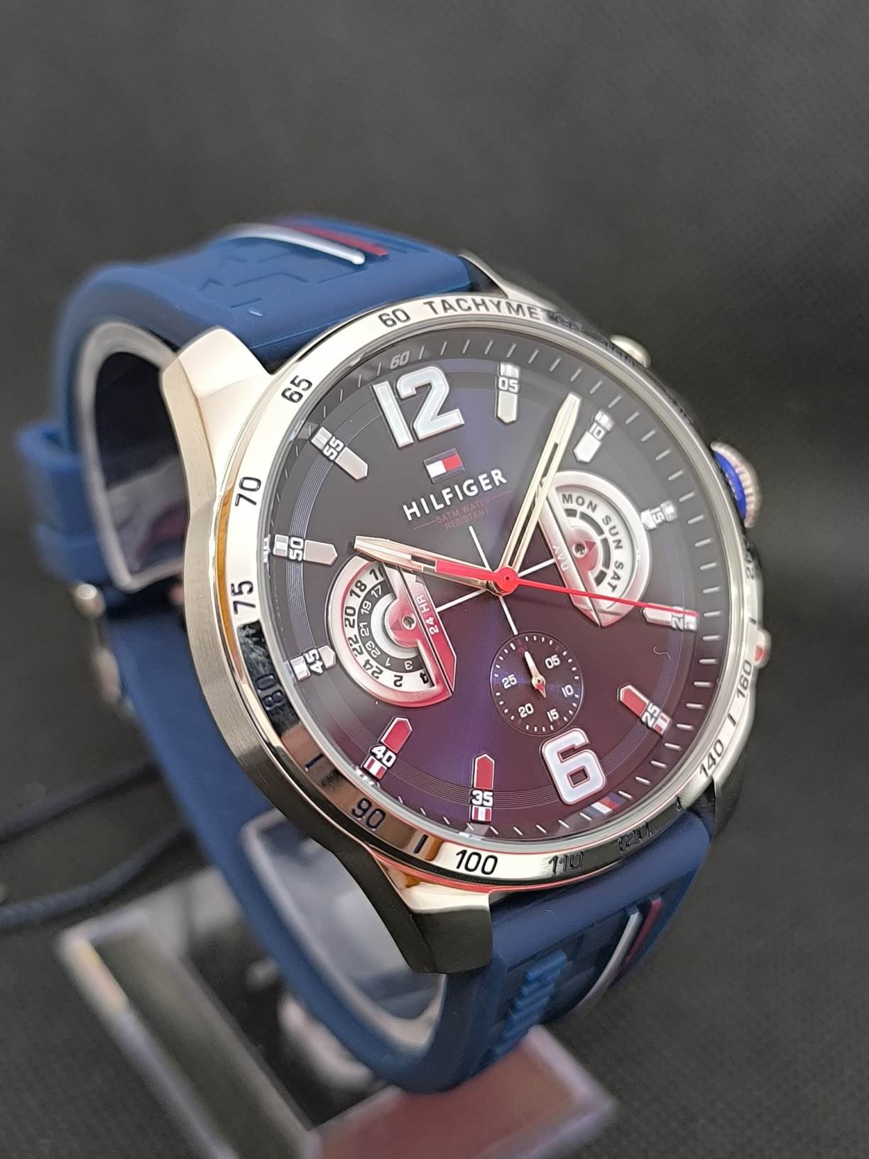 Reloj Tommy Hilfiger TH1791476, destacando su caja de 46 mm de diámetro en acero inoxidable, esfera azul con marcadores y agujas en contraste, y correa de silicona azul que proporciona comodidad y estilo deportivo. Ideal para uso diario y ocasiones casuales, combina modernidad y funcionalidad.