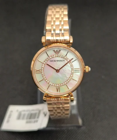 Reloj Emporio Armani AR1909 en oro rosa con esfera nacarada y cristales brillantes. Diseño sofisticado con correa de eslabones y resistencia al agua 3 ATM.