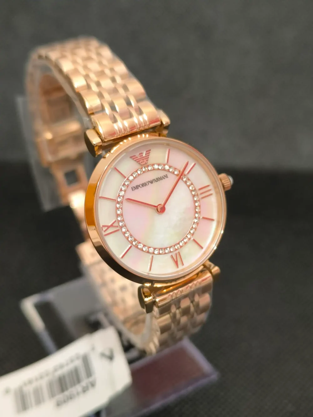 Reloj Emporio Armani AR1909 en oro rosa con esfera nacarada y cristales brillantes. Diseño sofisticado con correa de eslabones y resistencia al agua 3 ATM.