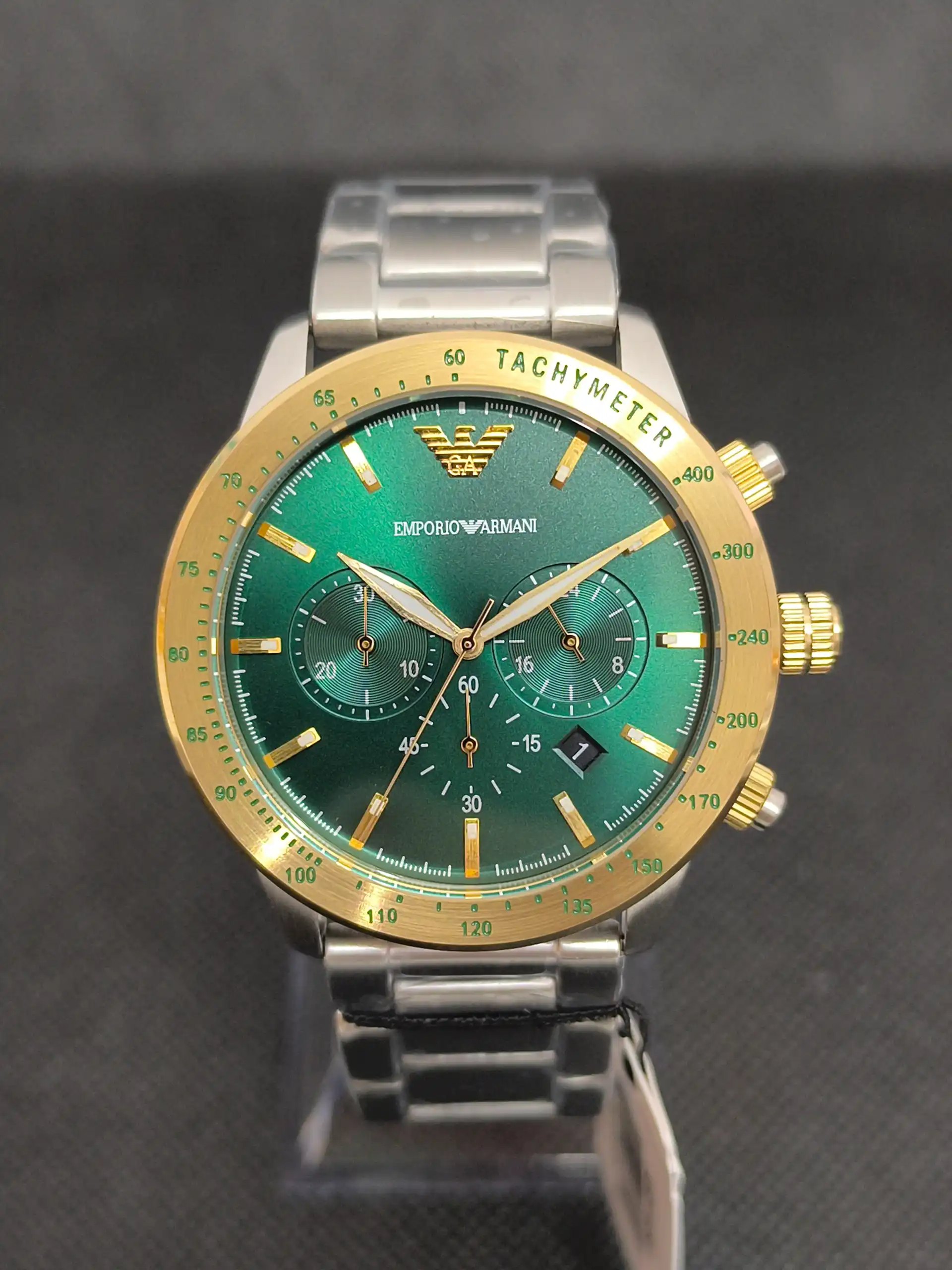 Reloj Emporio Armani AR11454 con esfera verde, bisel dorado y correa de acero inoxidable. Cronógrafo con taquímetro y resistencia al agua de 5 ATM.