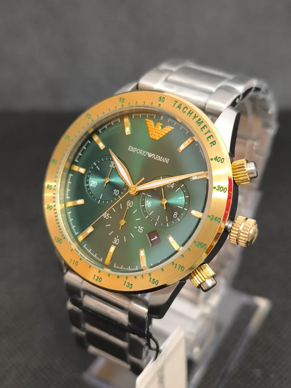 Reloj Emporio Armani AR11454 con esfera verde, bisel dorado y correa de acero inoxidable. Cronógrafo con taquímetro y resistencia al agua de 5 ATM.