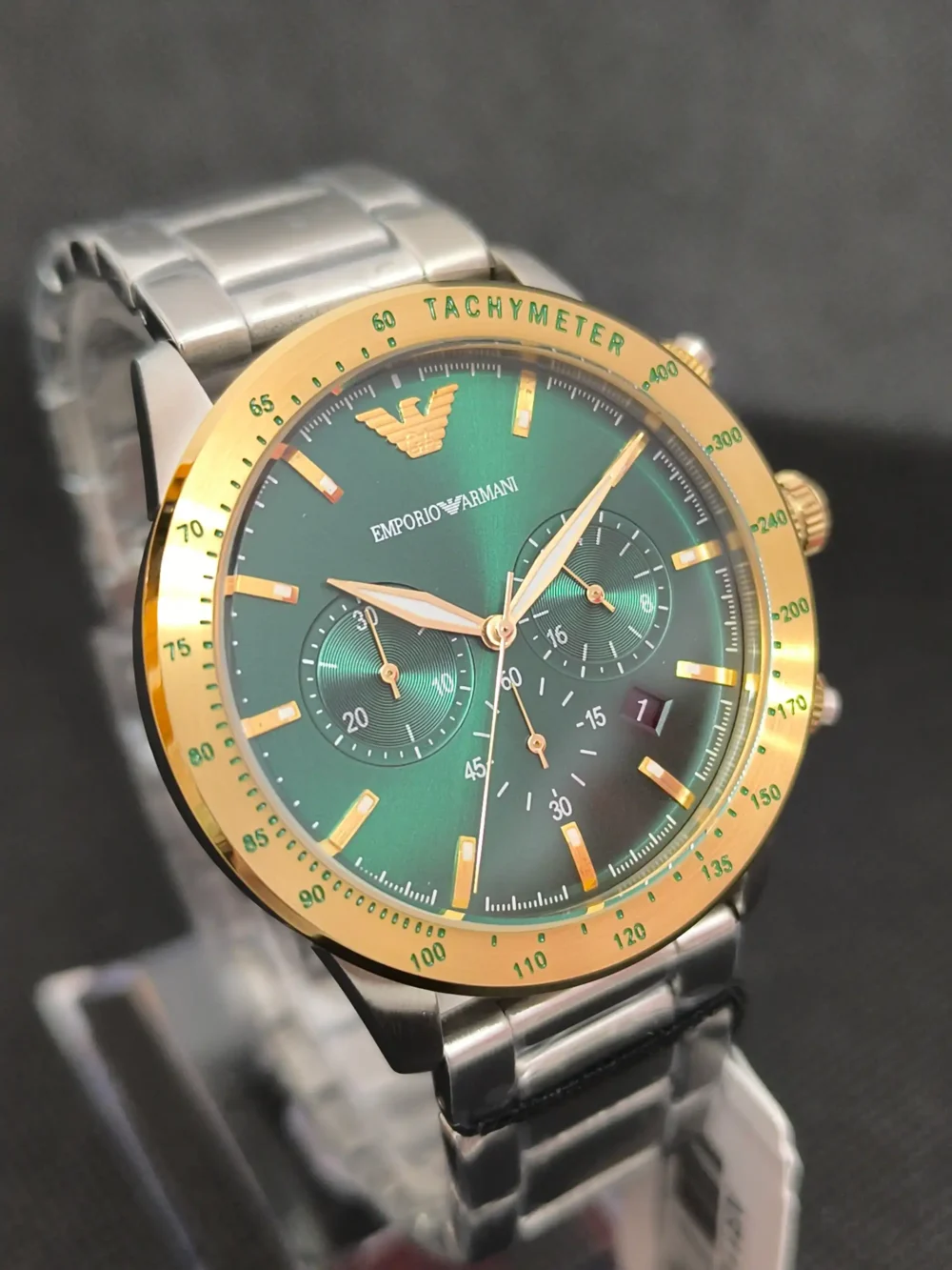 Reloj Emporio Armani AR11454 con esfera verde, bisel dorado y correa de acero inoxidable. Cronógrafo con taquímetro y resistencia al agua de 5 ATM.