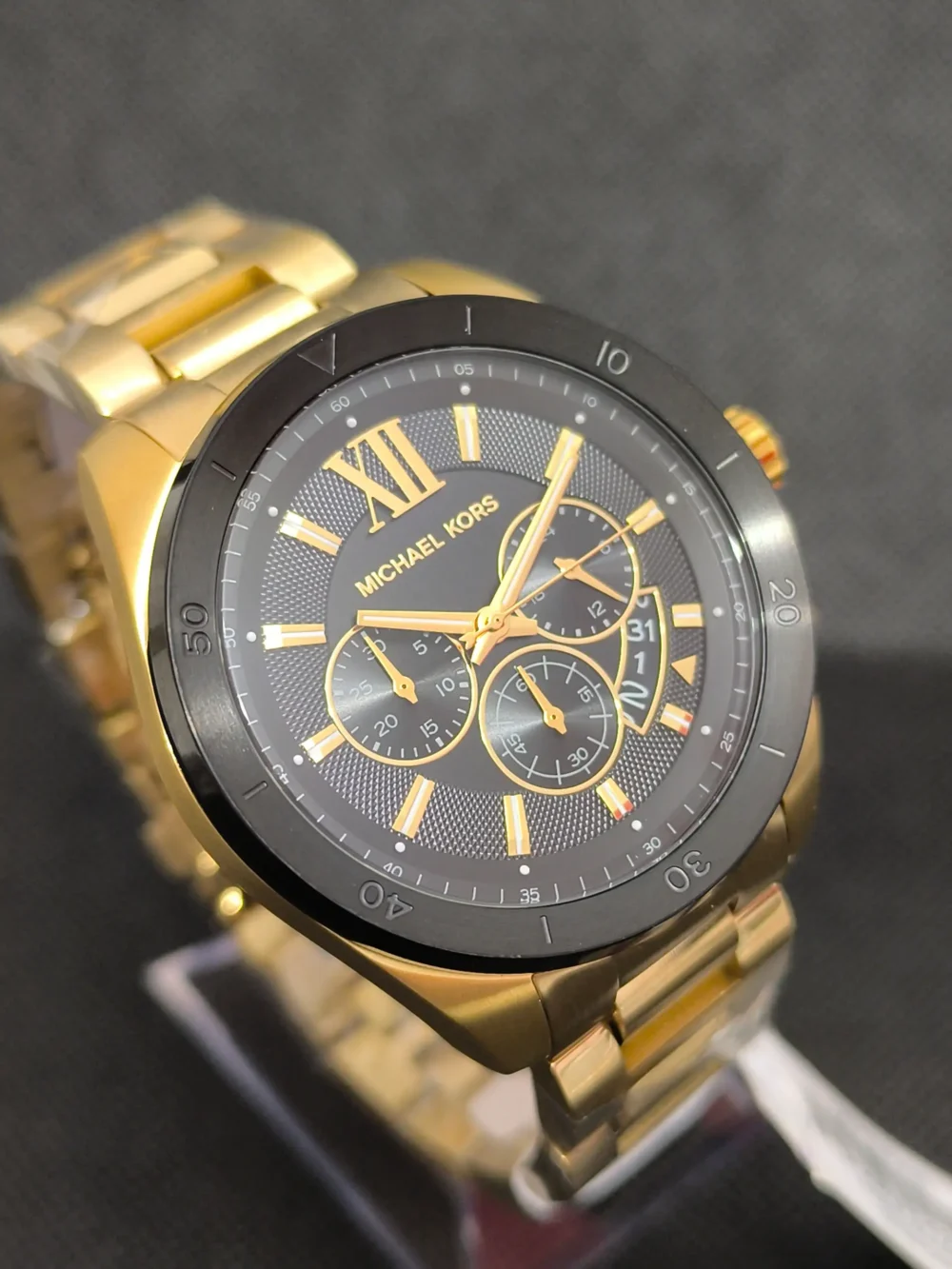 Reloj Michael Kors MK8848 caja dorada, esfera negra con cronógrafo y resistencia al agua de 10 ATM.