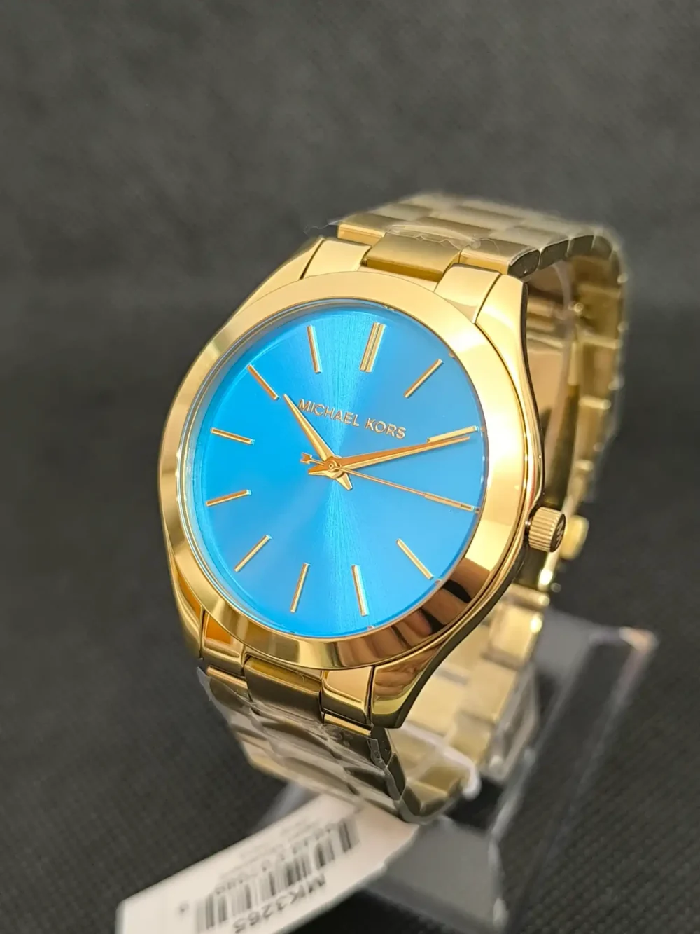 Reloj Michael Kors Slim Runway MK3265 con caja dorada y esfera azul brillante. Diseño minimalista, correa de acero inoxidable y resistencia al agua 5 ATM.