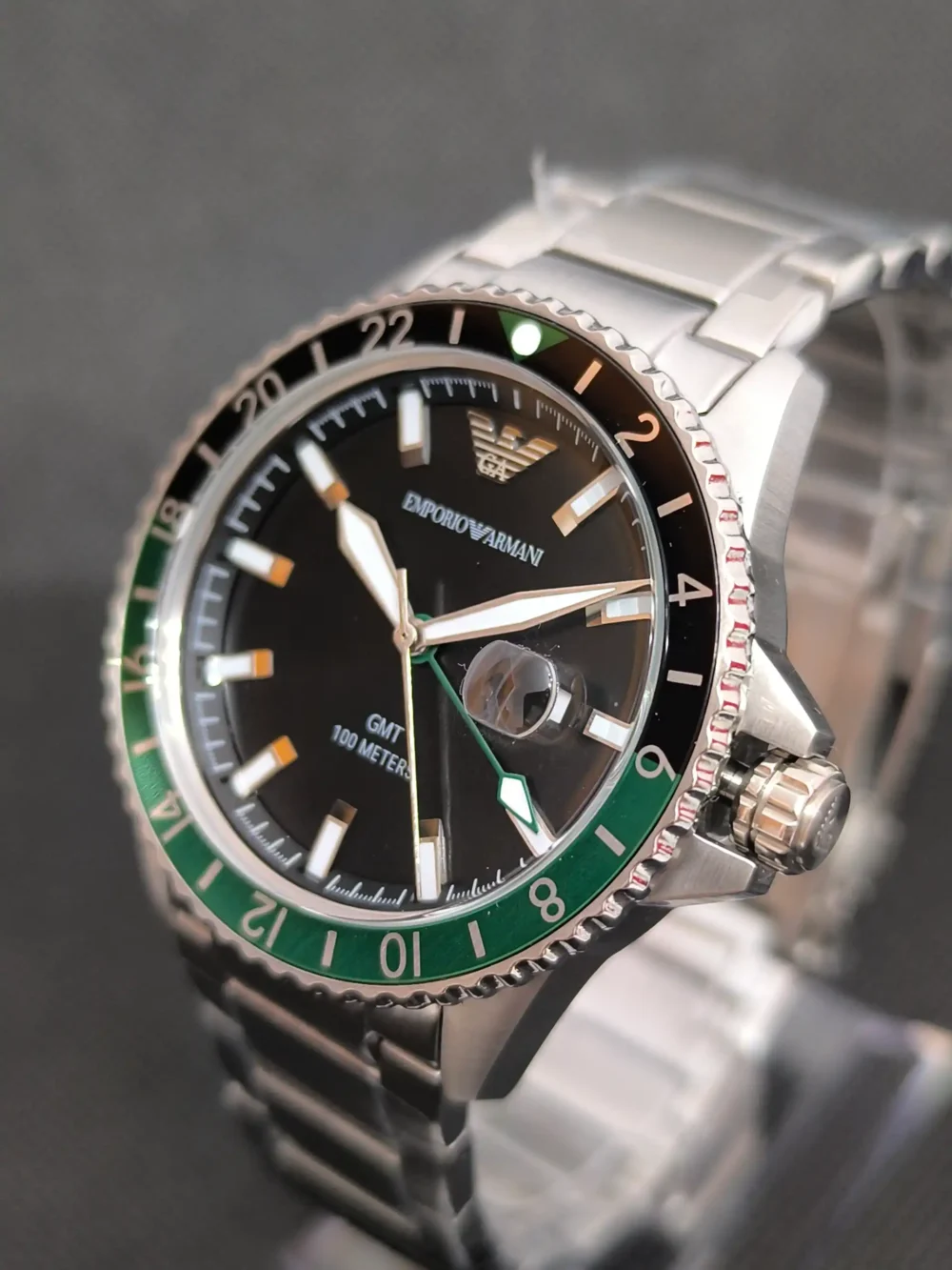 Reloj Emporio Armani Diver AR11589 GMT con bisel bicolor verde y negro, función GMT y esfera negra con marcadores luminosos.