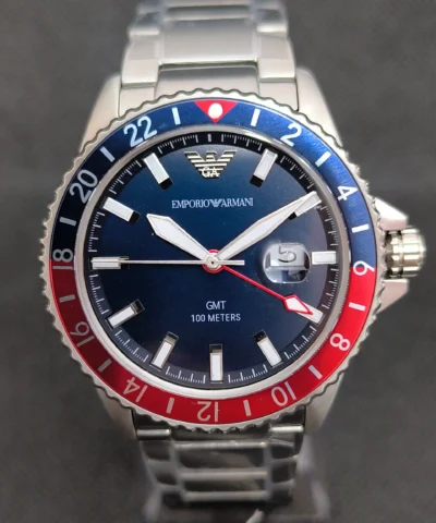 Reloj Emporio Armani Diver AR11590 GMT con bisel bicolor rojo y azul, función GMT y esfera azul con marcadores luminosos.