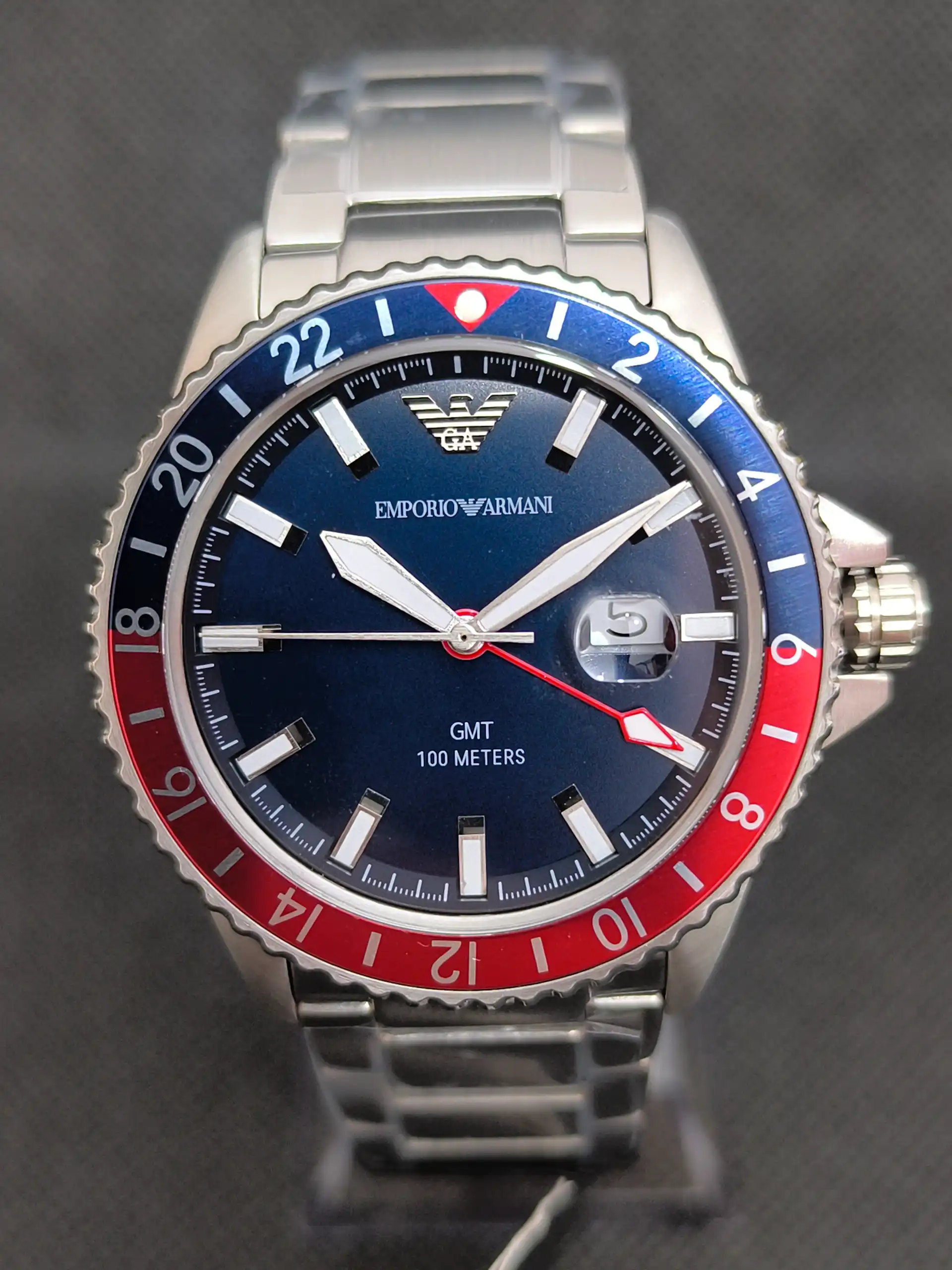 Reloj Emporio Armani Diver AR11590 GMT con bisel bicolor rojo y azul, función GMT y esfera azul con marcadores luminosos.