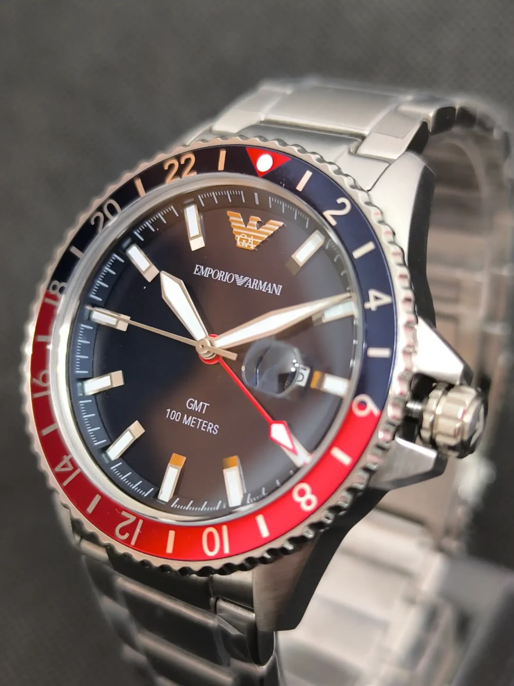 Reloj Emporio Armani Diver AR11590 GMT con bisel bicolor rojo y azul, función GMT y esfera azul con marcadores luminosos.